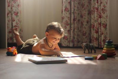 Baby van zes maanden die speelt op een kleurrijke activiteitenmat