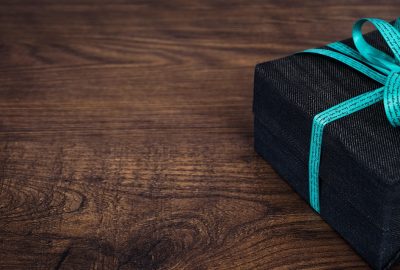 Een tiener pakt een cadeau uit met een neutrale blik
