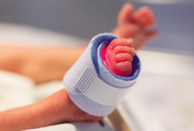 Premature baby in een couveuse op de NICU omgeven door medische apparatuur