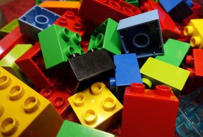 Twee jonge kinderen spelen samen met bouwblokken op de vloer