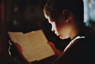 Kind van rond de tien jaar dat geconcentreerd een boek leest